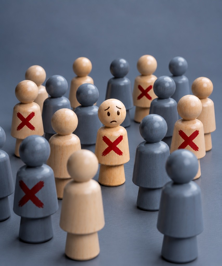 Wooden figures in a crowd, several marked with a red cross, and one worried figure in the centre